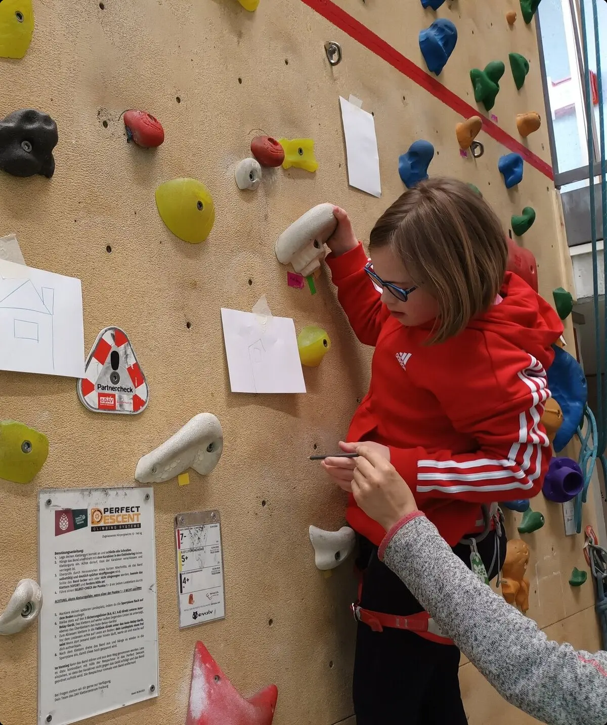 Ein Kind löst ein Rätsel an einer Boulderwand | © DAV/Freiburg-Breisgau/Josephine Kerzel/Klettern mit Handicap