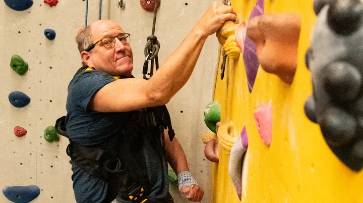Ein inklusiver Mann klettert in der großen Halle am Seil | © DAV/Freiburg-Breisgau/Josephine Kerzel/Climb-All-In