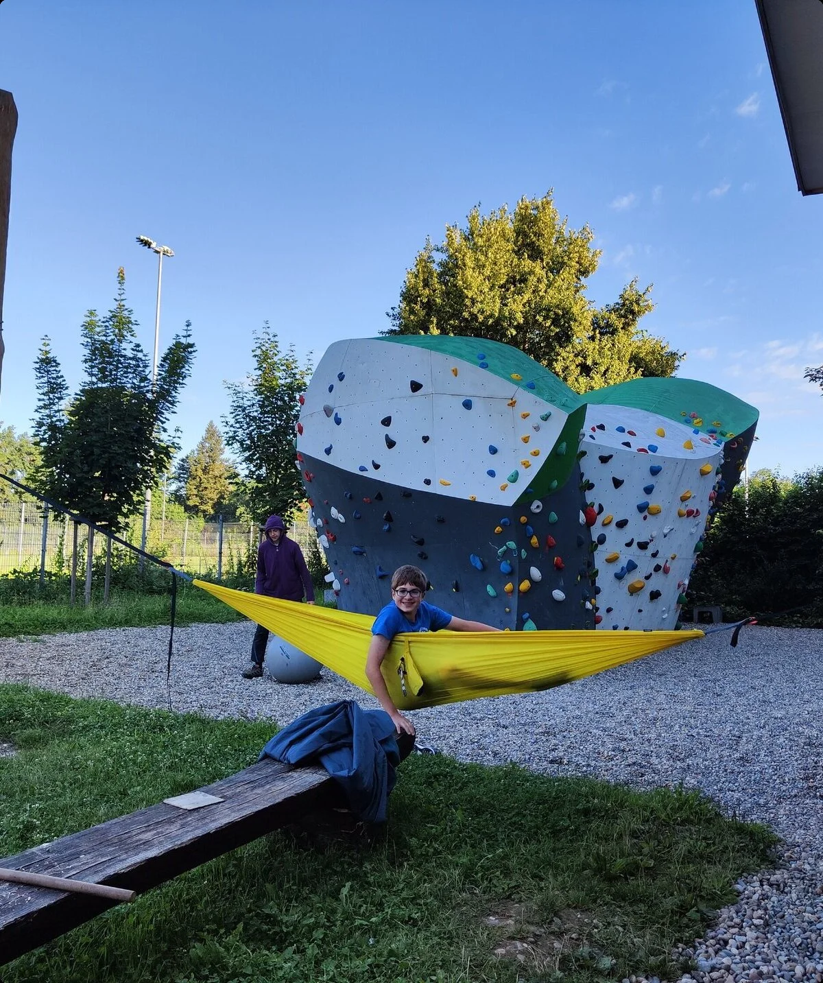 Eine Person liegt in einer Hängematte vor dem Boulderblock | © DAV/Freiburg-Breisgau/Josephine Kerzel/Wolfsbande
