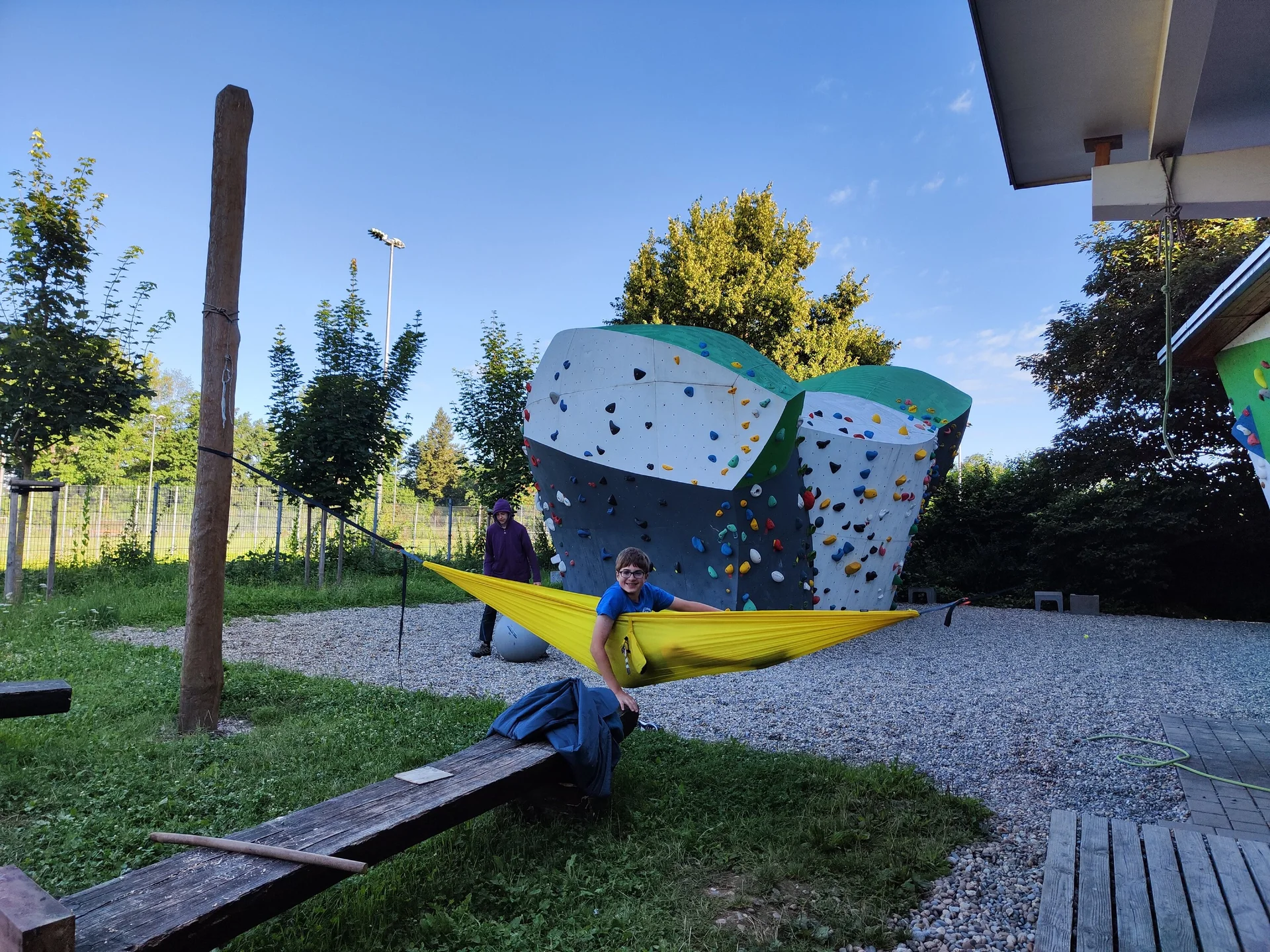 Eine Person liegt in einer Hängematte vor dem Boulderblock | © DAV/Freiburg-Breisgau/Josephine Kerzel/Wolfsbande