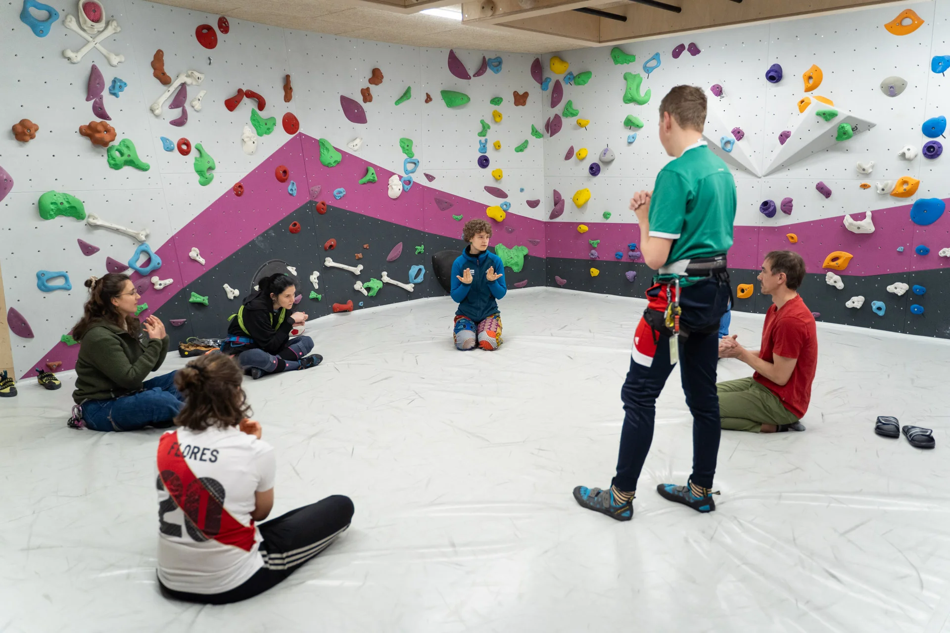 Eine Gruppe Erwachsene wärmt sich im Boulderraum auf | © Maja Rohde
