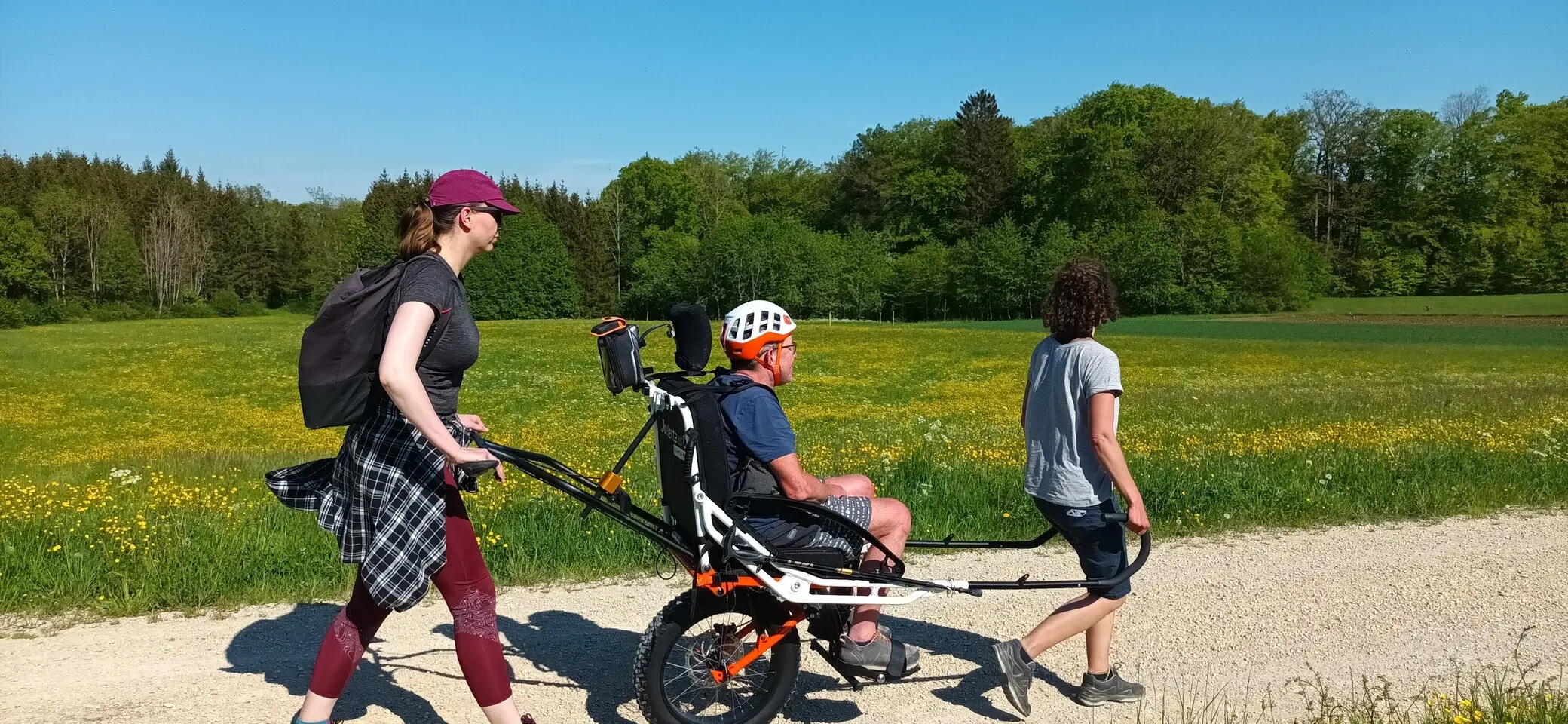 Zwei Personen schieben einen Mann im Wanderrollstuhl | © DAV/Freiburg-Breisgau/Josephine Kerzel/Tageswanderungen Inklusion