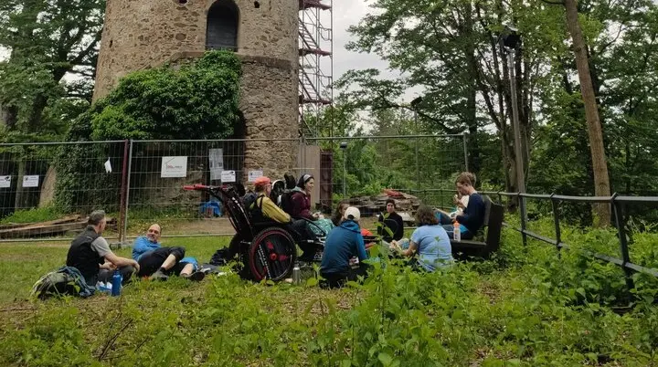 Die Wandernden rasten vor einem alten Burgturm | © DAV/Freiburg-Breisgau/Josephine Kerzel/Wanderungen