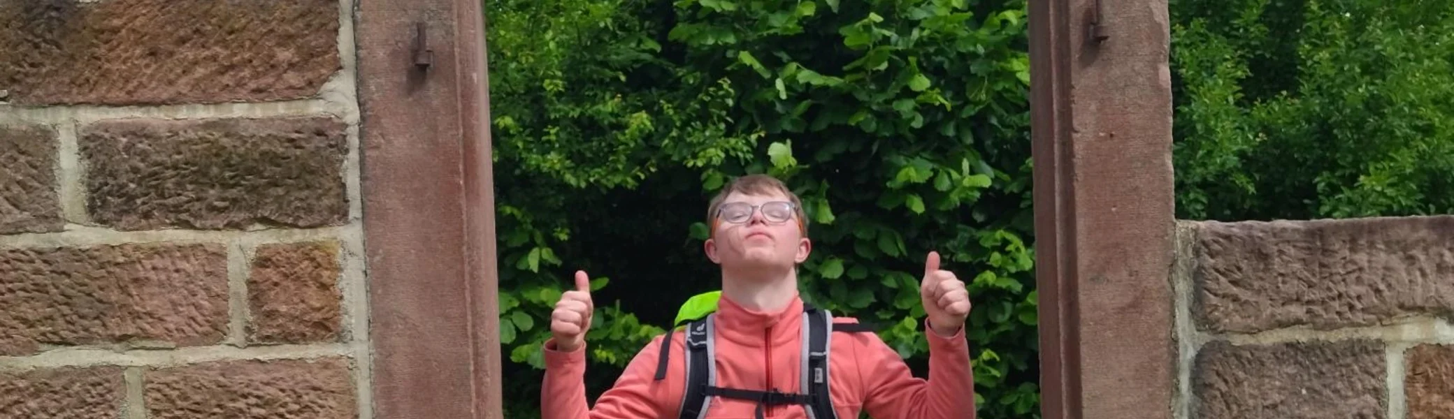 Ein Jugendlicher posiert in einem steinernen Fensterrahmen | © DAV/Freiburg-Breisgau/Josephine Kerzel/Wanderungen