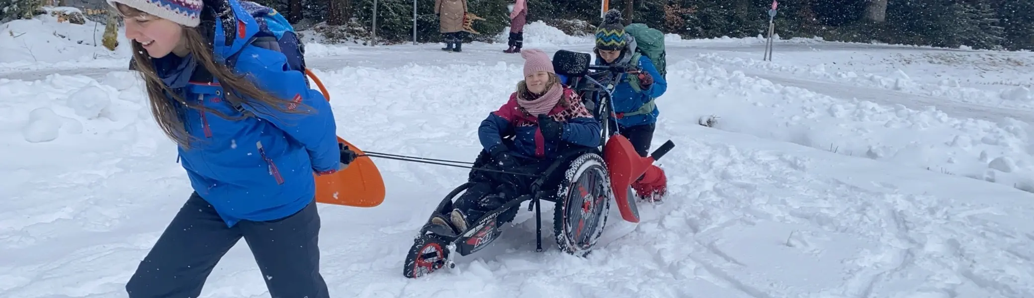 Eine Gruppe Jugendlicher unternehmen eine Winterwanderung mit Schneeschuhen und Wanderrollstuhl. | © DAV/Freiburg-Breisgau
