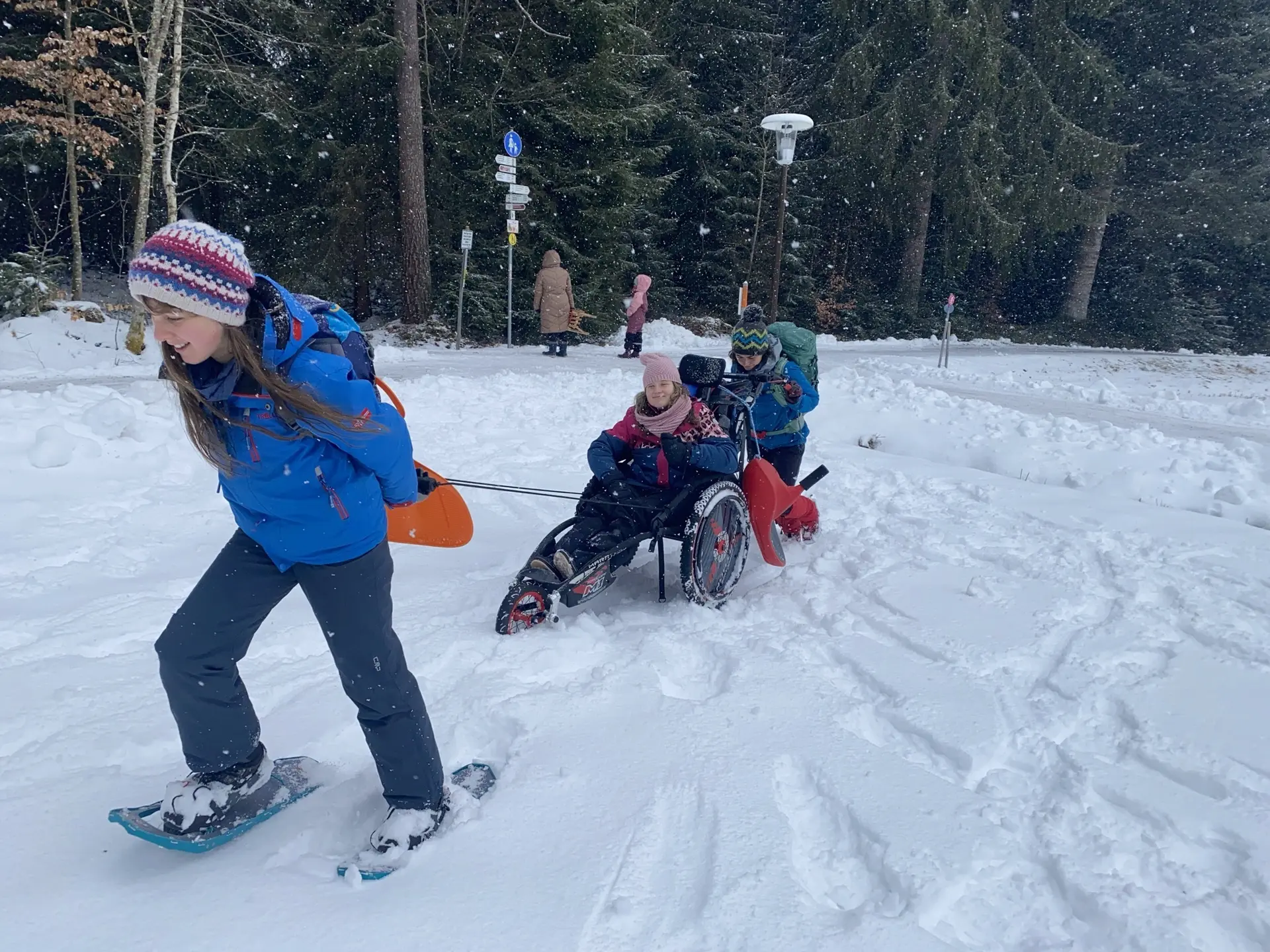 Eine Gruppe Jugendlicher unternehmen eine Winterwanderung mit Schneeschuhen und Wanderrollstuhl. | © DAV/Freiburg-Breisgau