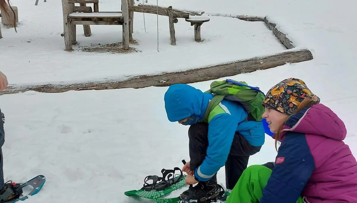 Zwei Jugendliche ziehen ihre Schneeschuhe an. | © DAV/Freiburg-Breisgau