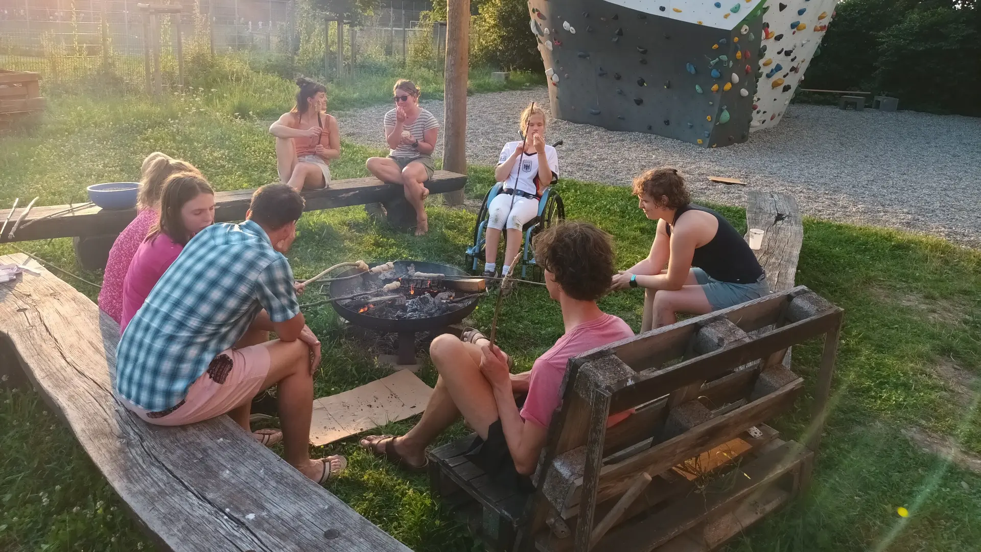 Eine inklusive Gruppe Kinder und Erwachsener sitzen um ein Feuer und machen Stockbrot | © DAV/Freiburg-Breisgau/Josephine-Kerzel/Inklusion